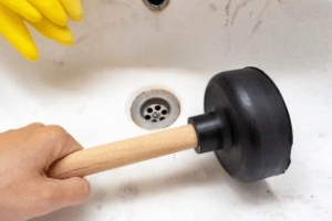 A Plunger Being Used For Removing The Clog From Bath Tub 