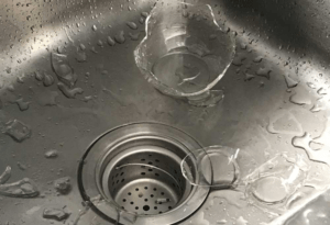 A broken glass on a kitchen sink