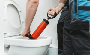 Man Cleaning Clogged Toilet