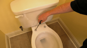 Professional plumber is installing screws to replace the new toilet seat